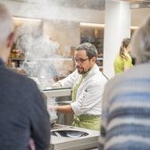 Koch am Arbeiten mit Gästen